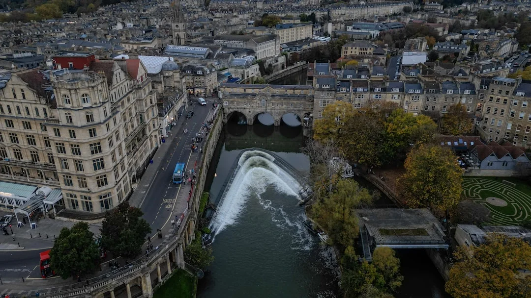 Aerial view of Pulteney Bridge and the horseshoe-shaped weir on the River Avon in Bath, surrounded by historic buildings