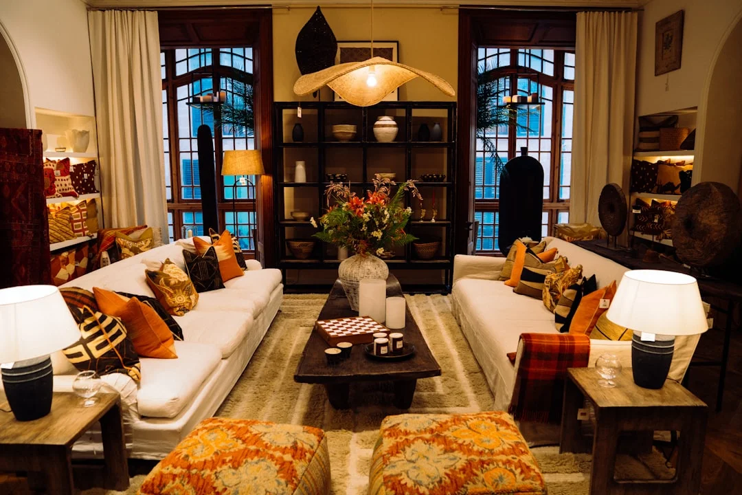 Luxurious living room with two white sofas, orange decorative pillows, and a dark wood coffee table in Brighton