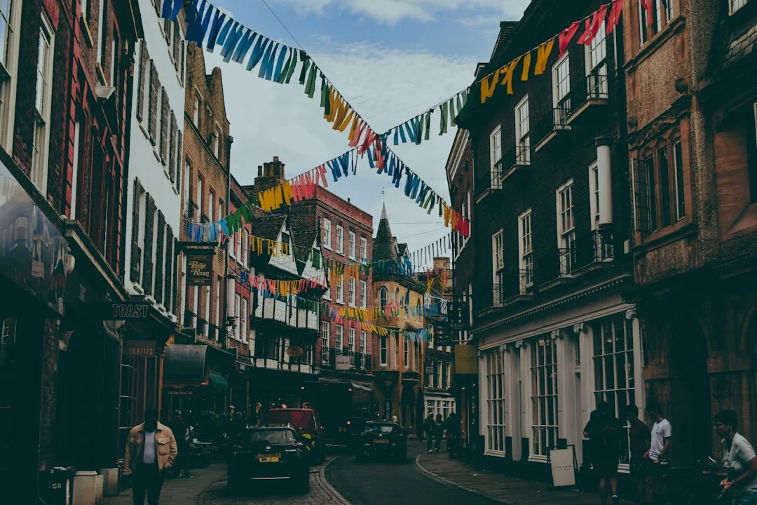Narrow street in Cambridge with historic buildings and colorful bunting hanging overhead