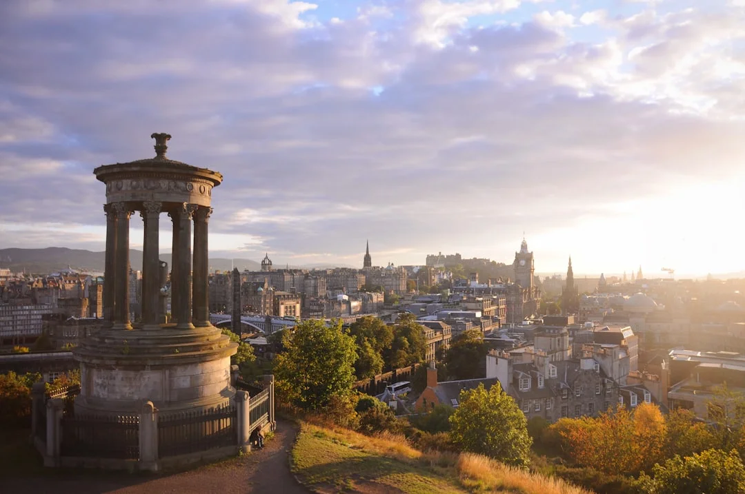 The Dugald Stewart Monument on Calton Hill overlooking the Edinburgh cityscape at sunrise