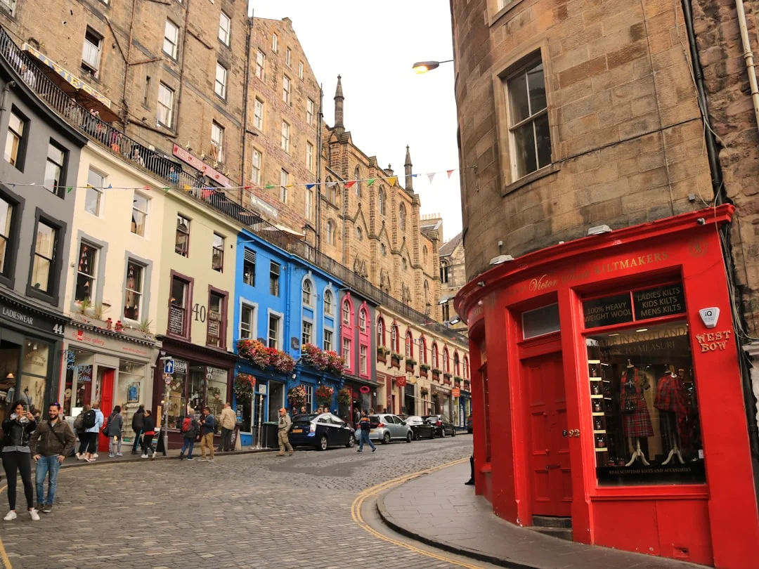 Colorful storefronts and cobblestone streets of Victoria Street in Edinburgh's Old Town