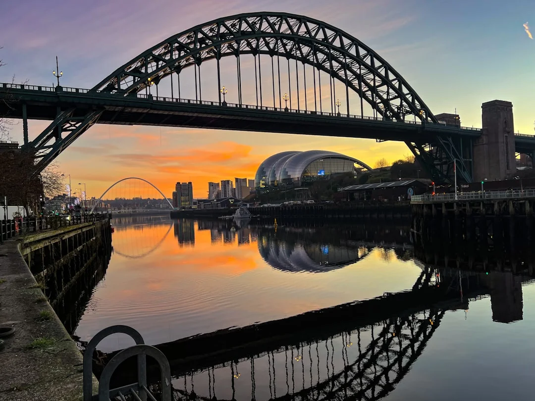 Sunrise over the Tyne Bridge and Sage Gateshead with reflections on the calm river water in Newcastle