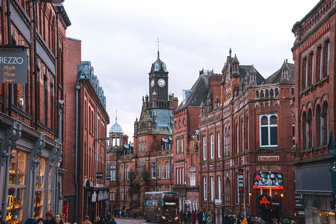 Red brick buildings and a clock tower line a busy street in Nottingham city centre