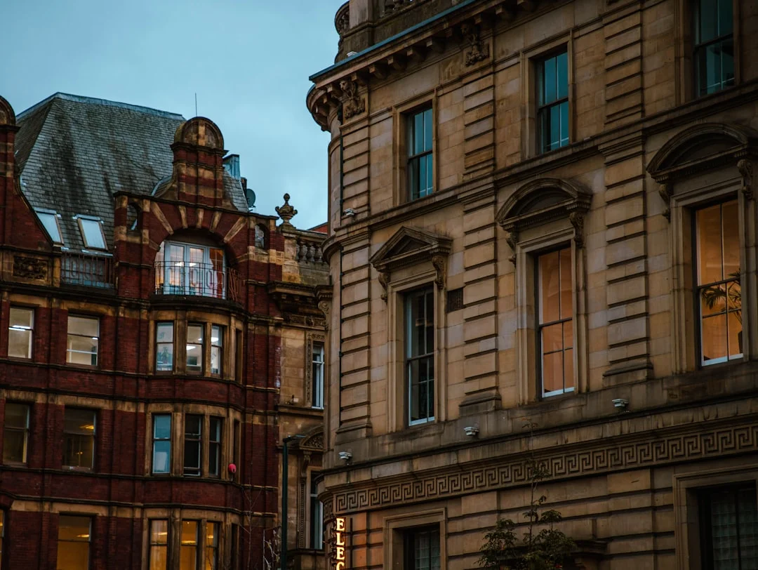 Ornate historic buildings in Leeds at twilight with warm light shining from the windows