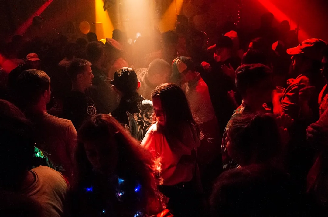 Crowded nightclub dance floor in Liverpool illuminated by dramatic red and yellow stage lighting