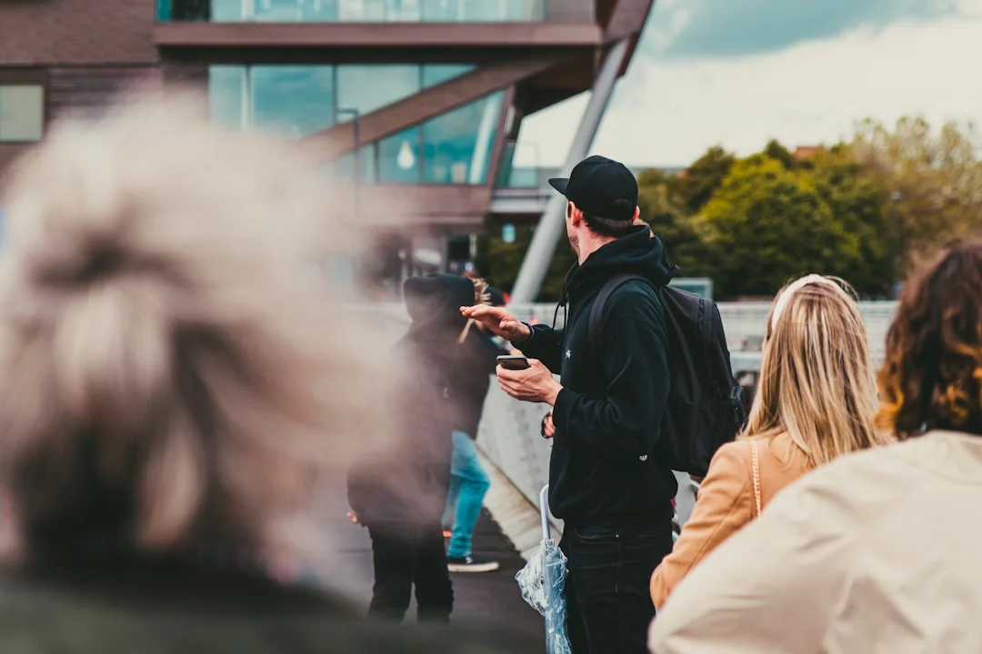 A group of people standing near a modern glass building in an urban setting