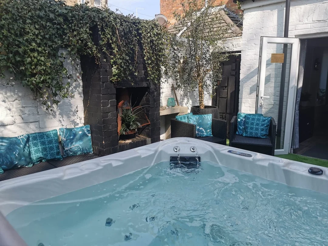 The outdoor patio area of a Bournemouth townhouse with a group of women relaxing in the hot tub.