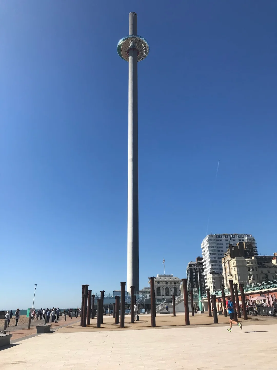 The British Airways i360 viewing pod ascending its tower against the Brighton seafront.