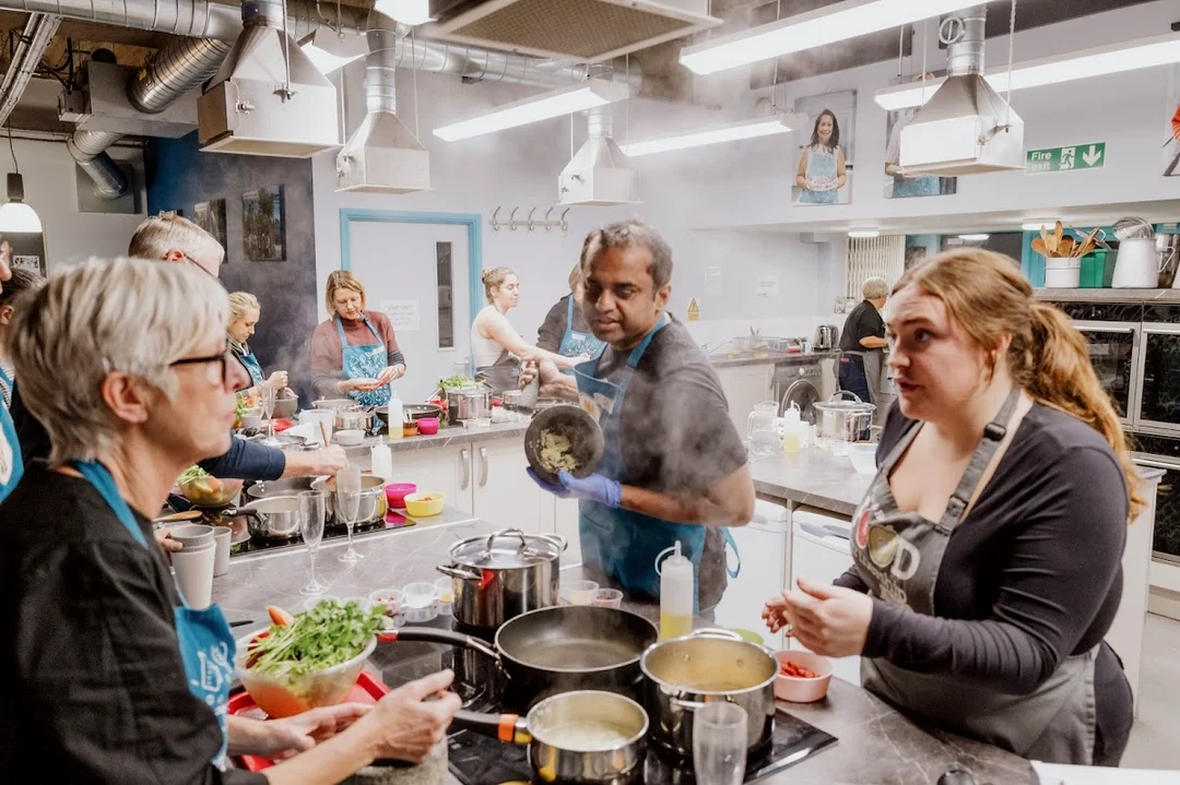 A group of people participating in a hands-on cooking class at the Community Kitchen in Brighton.
