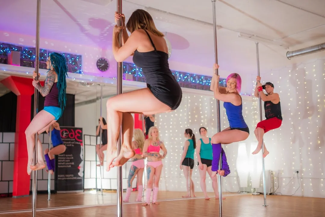 A group of women learning pole dancing moves during a fun hen party class at 360 Pole Dancing.
