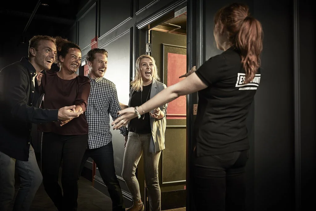 A group of friends working together to solve puzzles inside one of the themed Cambridge Escape Rooms.