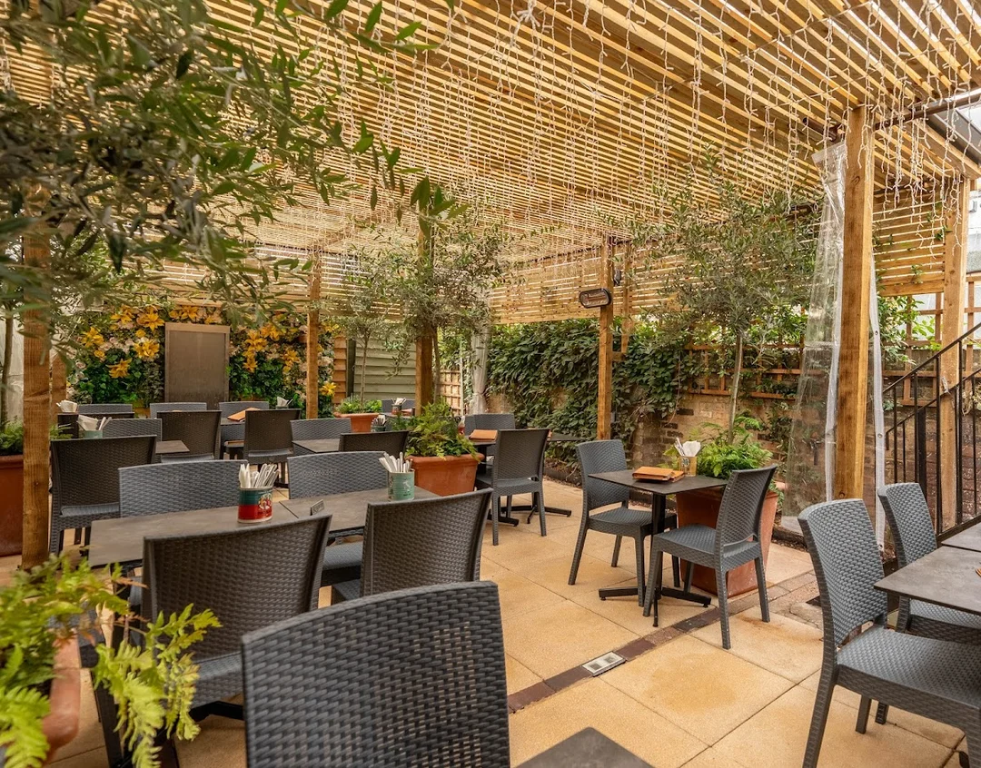 The charming all-weather pergola garden at Limoncello restaurant, set for a group meal.