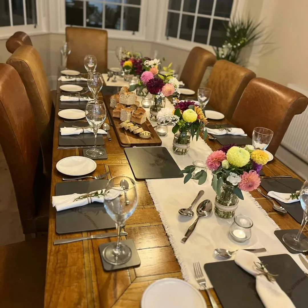 A private chef preparing a meal for a group of women in a holiday home kitchen.
