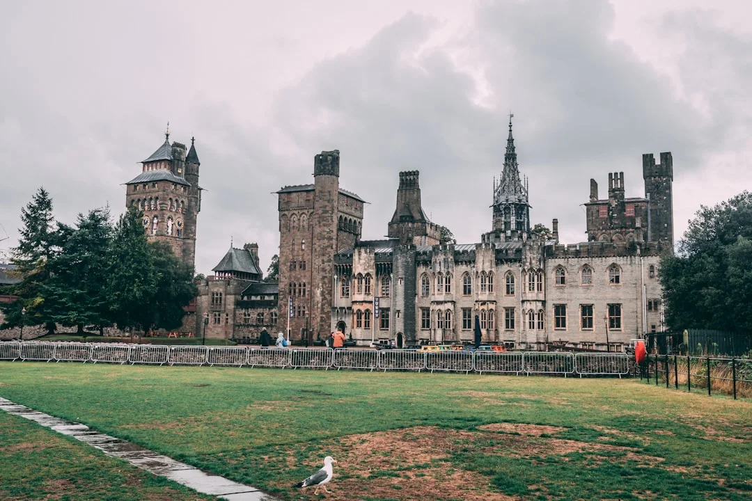 Cardiff Castle in Wales, featuring its historic clock tower, ornate Victorian Gothic architecture, and green lawn