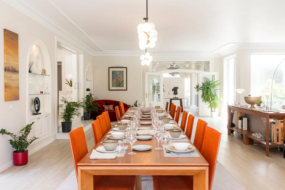Spacious, elegant dining room in a Cardiff hen party house, featuring a long table set for guests with orange chairs