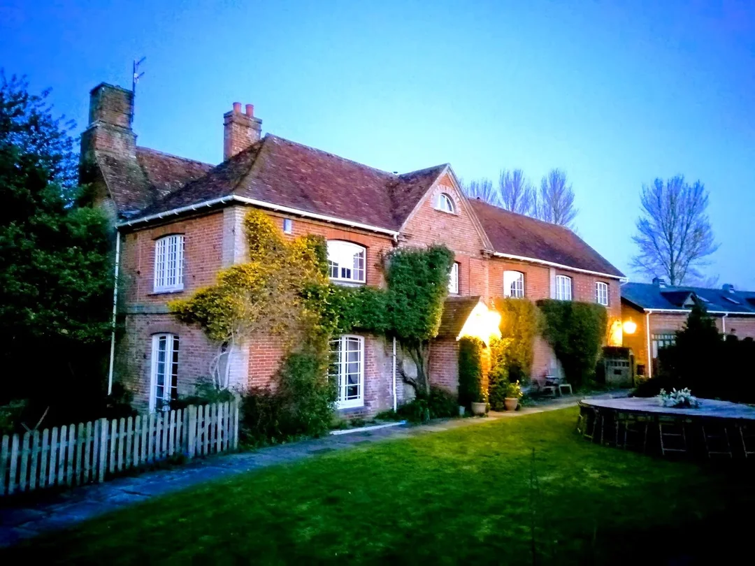 The exterior of Riverside Farmhouse Retreat showing the garden and outdoor seating area.