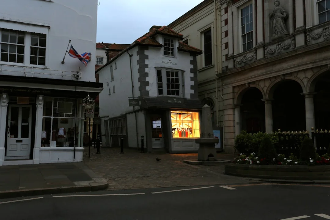 Cobbled streets in Windsor with historic white buildings and a glowing shop window at dawn
