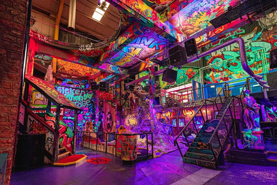 A group of friends playing crazy golf inside the vibrant, street-art-covered Golf Fang venue.