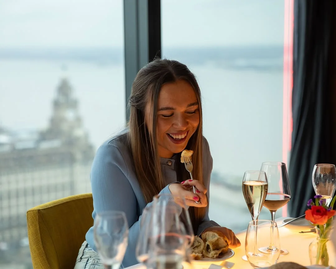 The elegant dining room at Panoramic 34, showing the incredible city views from the tall windows.