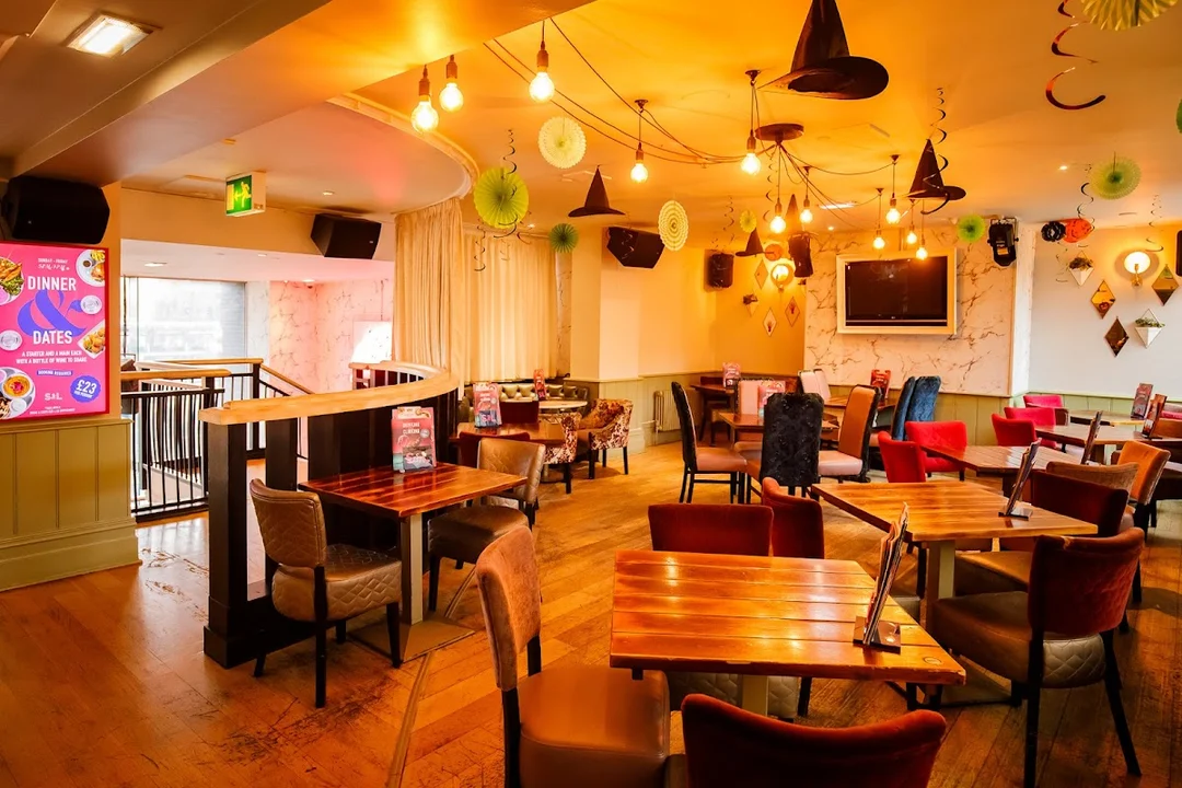 A group of friends enjoying a bottomless brunch with cocktails at a stylish Slug & Lettuce bar.