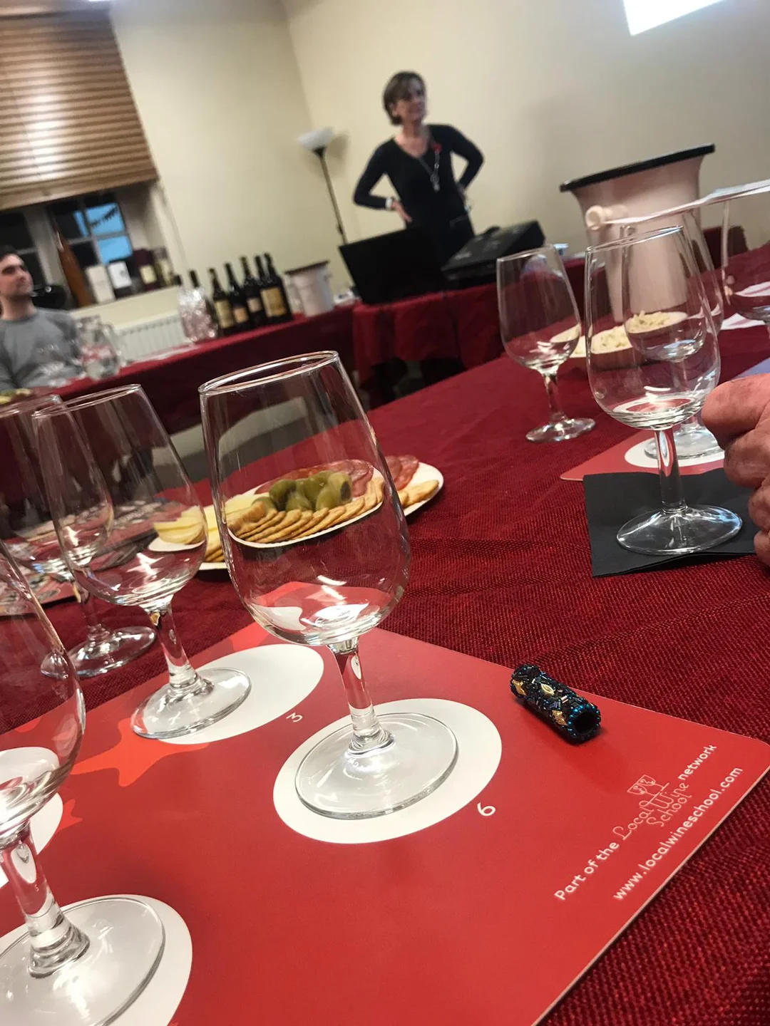 A sommelier leading a fun and informative wine tasting session for a hen party at home.