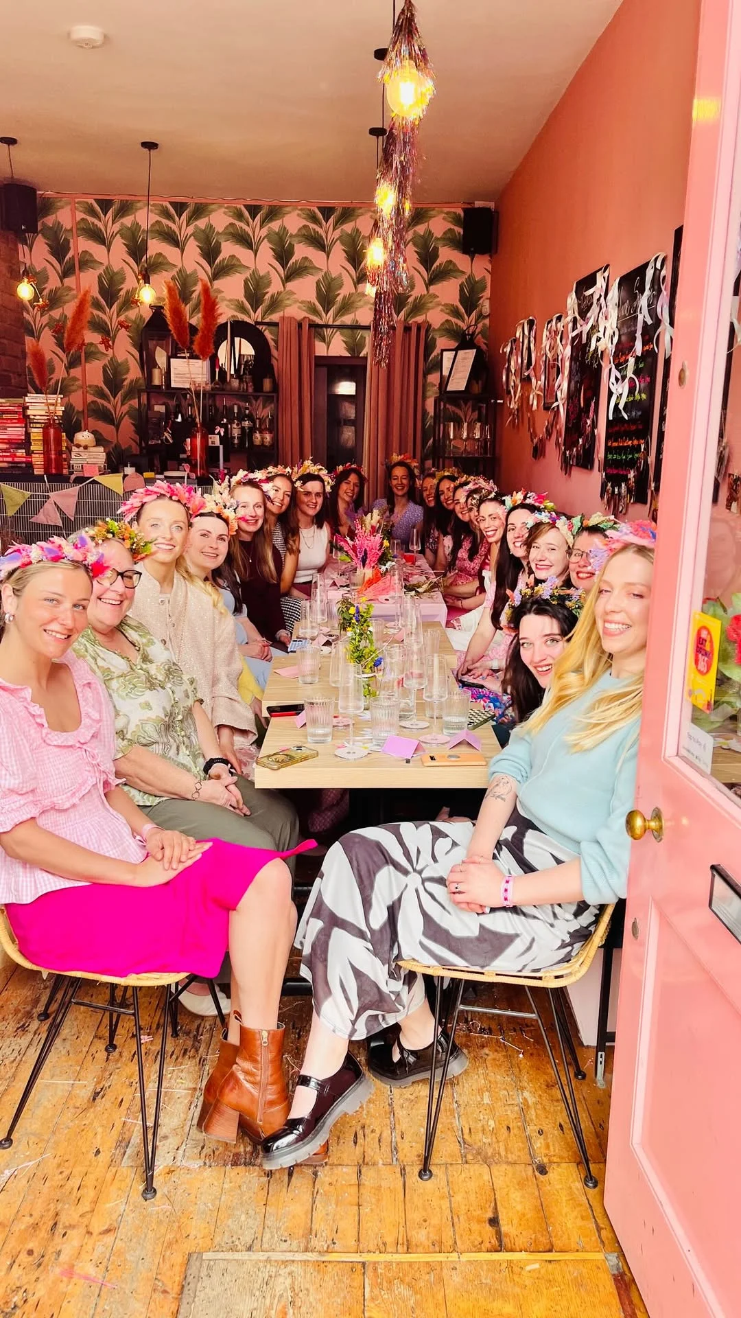 A hen party group proudly showing off the beautiful flower crowns they made during a workshop.