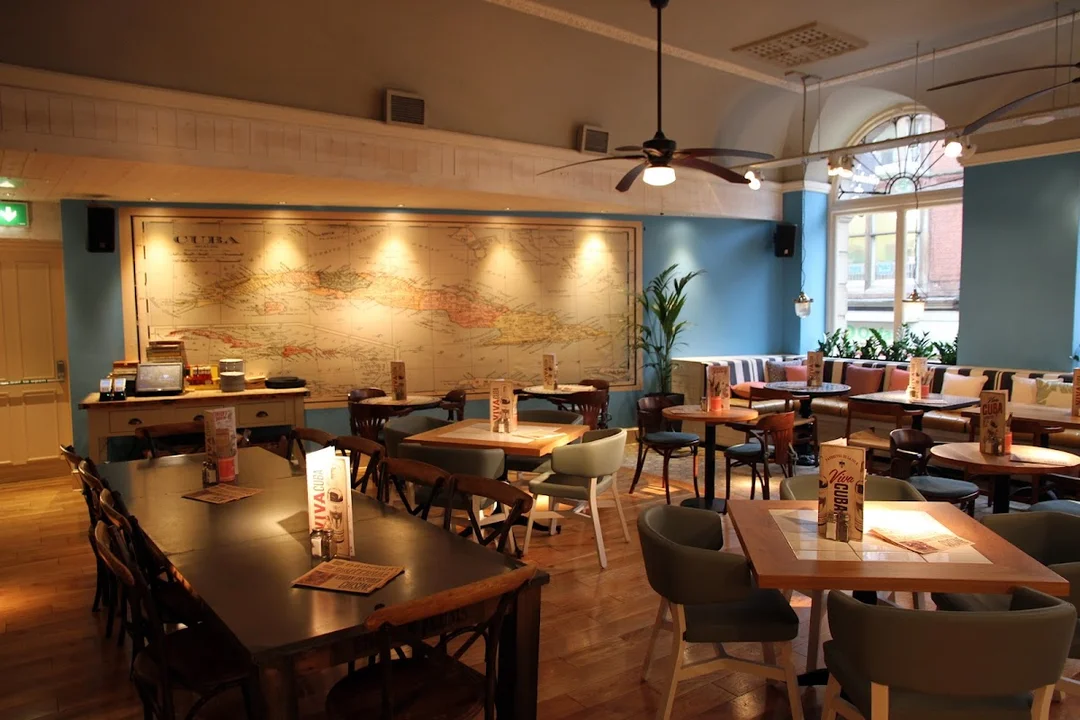 A group of friends enjoying a rum cocktail masterclass in the vibrant, Latin-inspired decor of Revolución de Cuba.