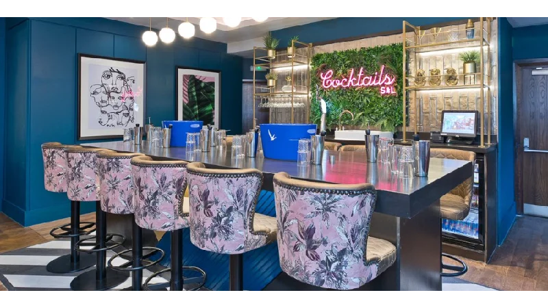 A group of friends enjoying cocktails and bottomless brunch at a vibrant Slug & Lettuce bar.