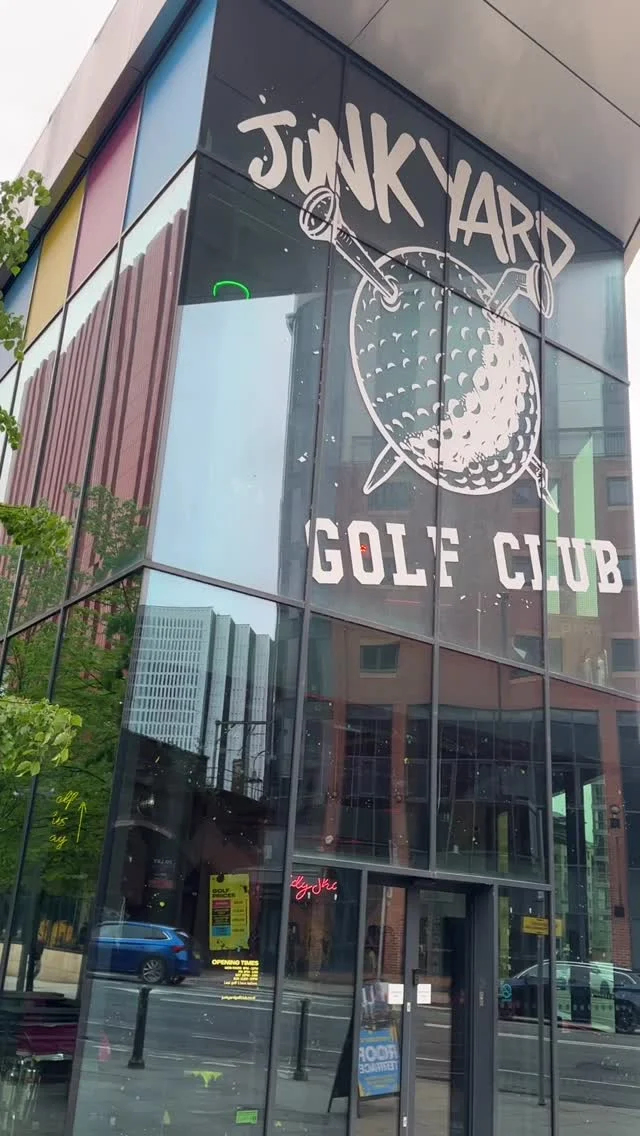 A group of friends playing crazy golf in the colourful, neon-lit interior of Junkyard Golf Club.